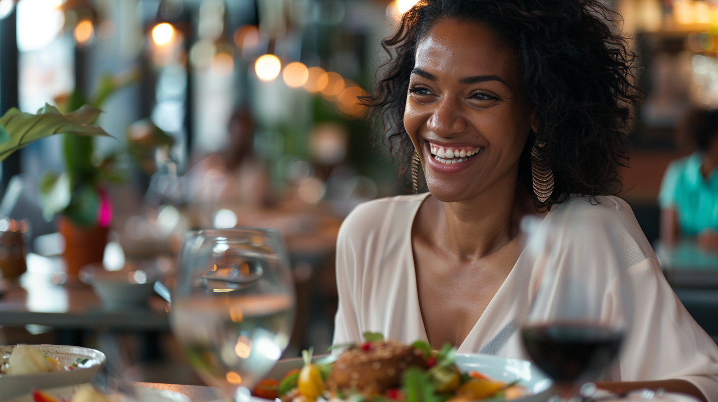 A smiling woman in her 40s delighting in her healthy meal at a restaurant.