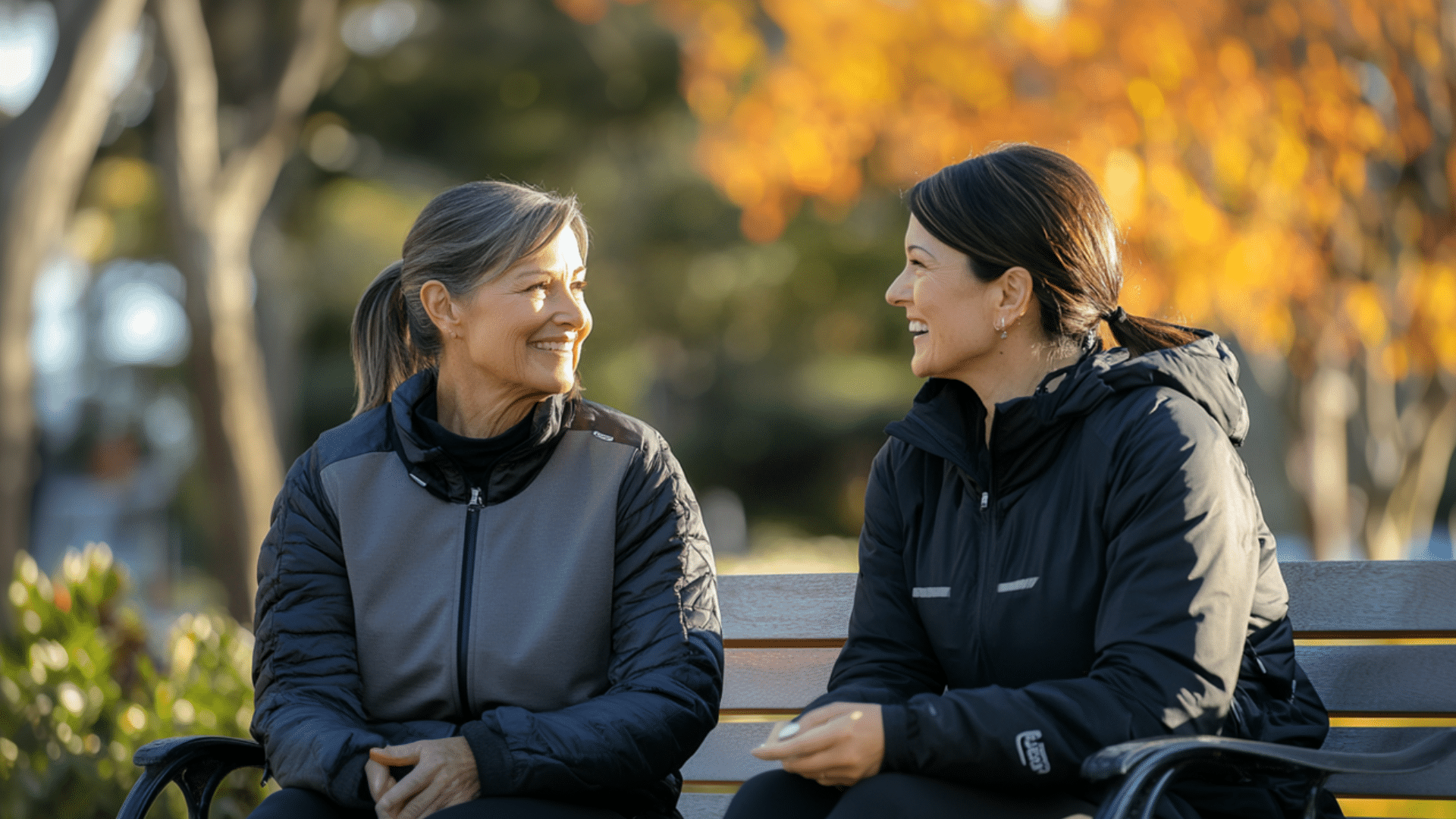 Two people talking in the park after exercising.