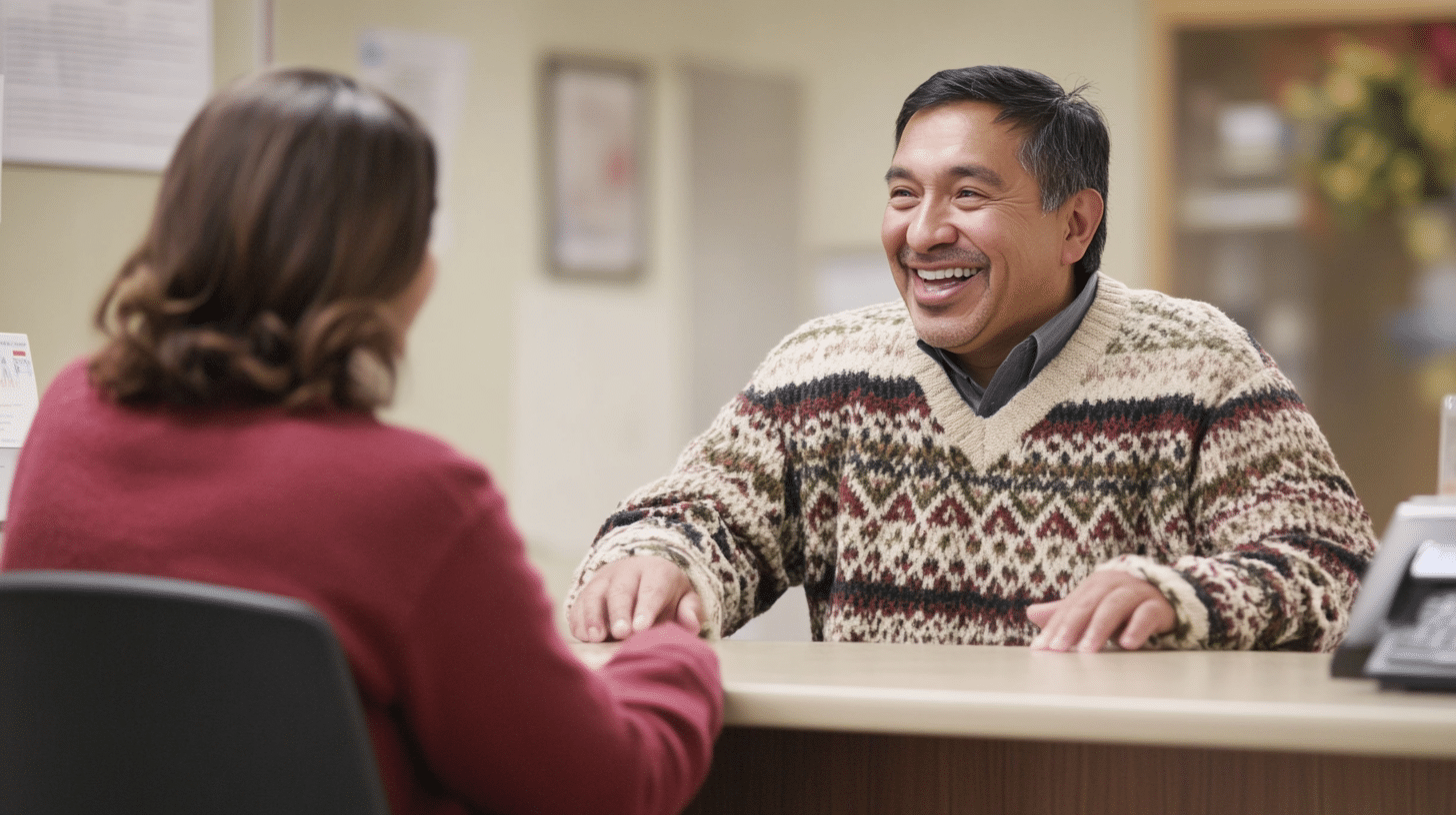 A Hispanic man talking politely with a nurse in the clinic lobby.