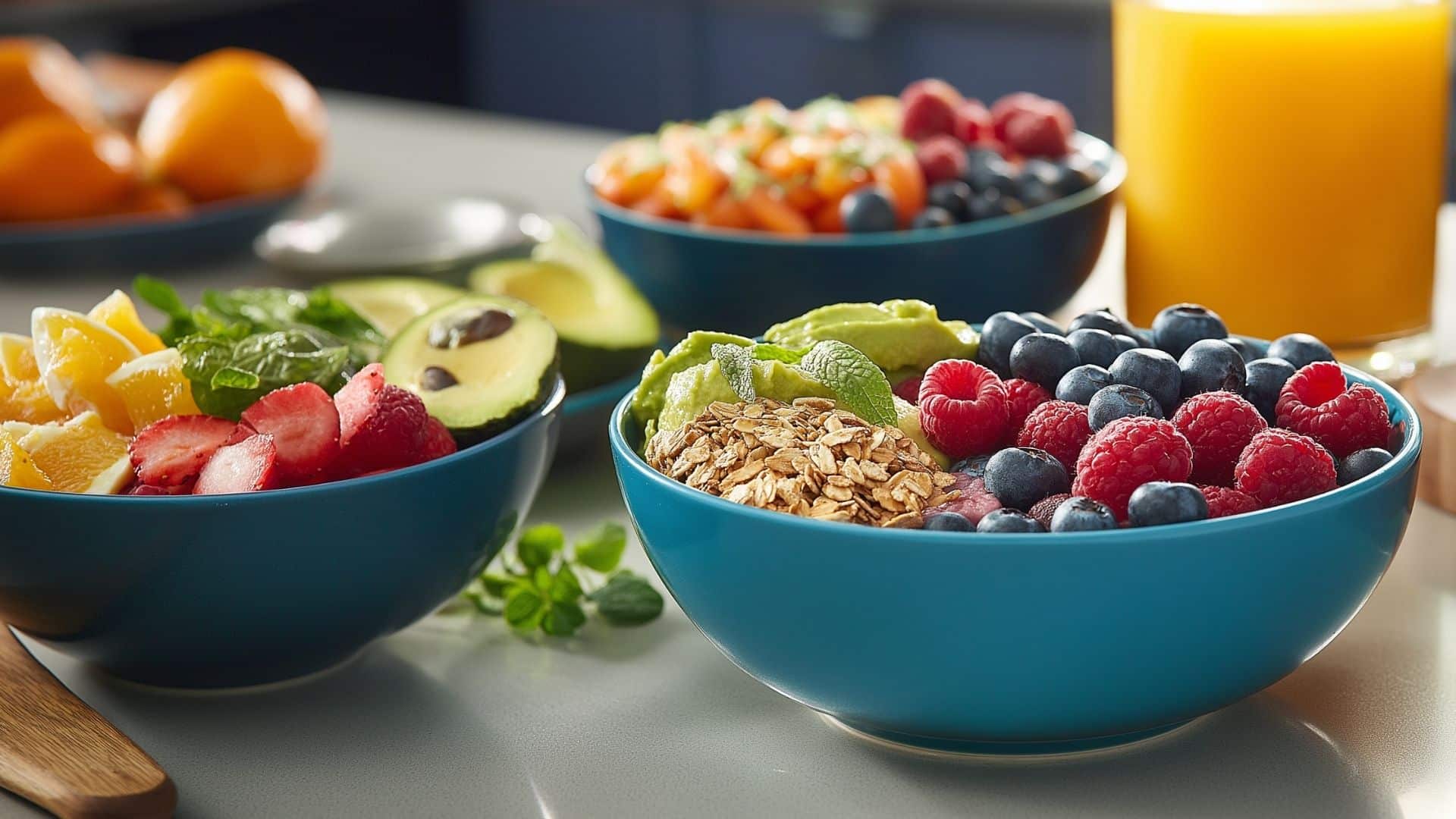 Bowls of colorful, fresh fruits and vegetables with a glass of orange juice.